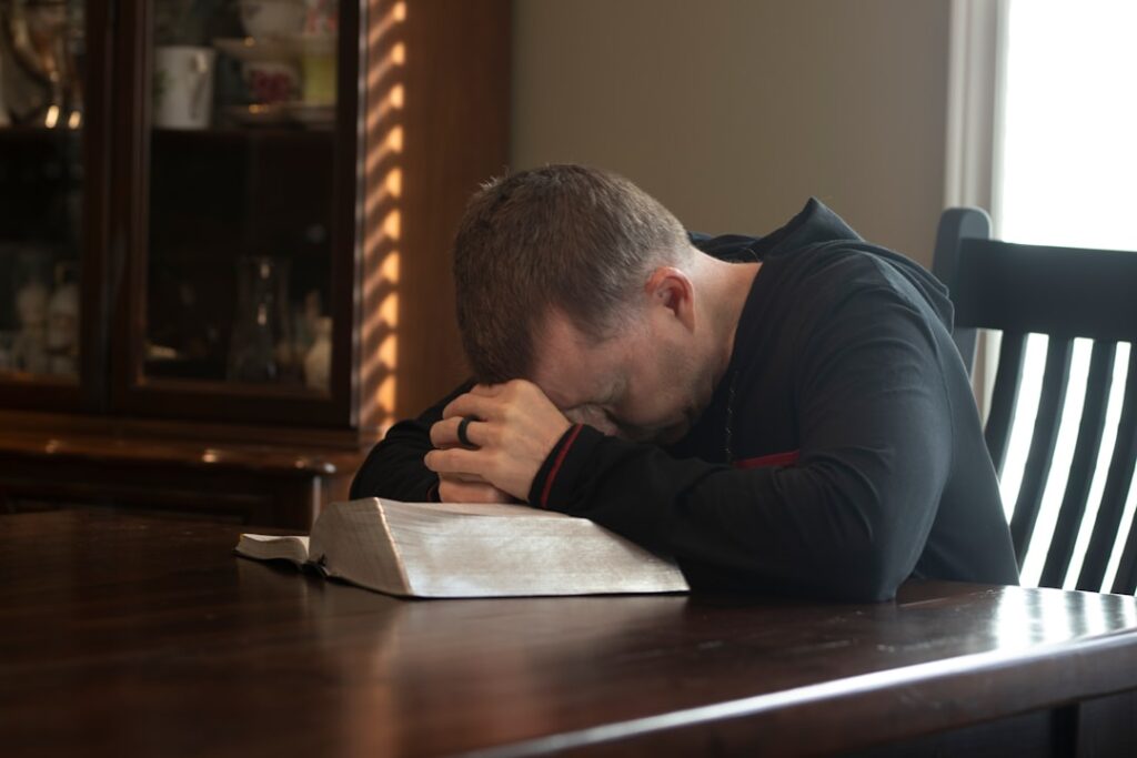 a man sitting at a table with his head in his hands